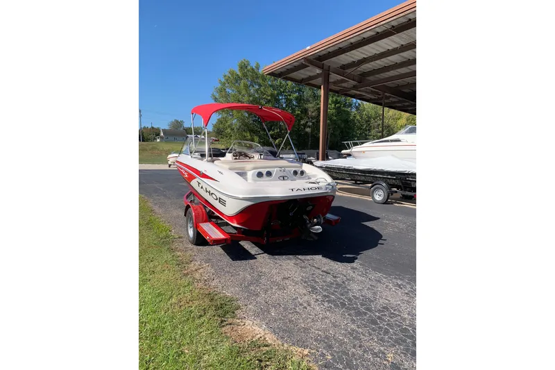 Slide: The Image of 2014 Tahoe Q5i Sport boat with red accents parked outdoors. - 3