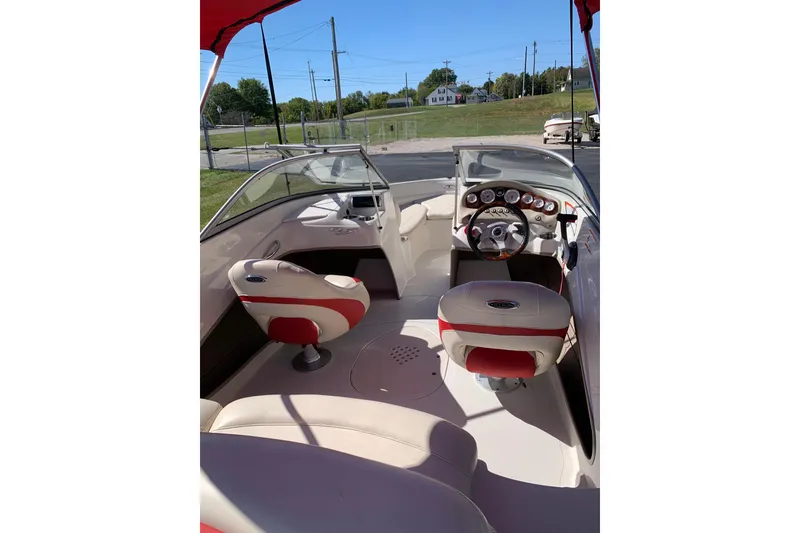 Slide: The Image of 2014 Tahoe Q5i Sport boat interior with red and white seating, steering wheel, and dashboard. - 5