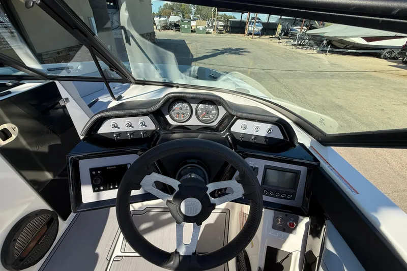 Slide: The Image of 2023 MasterCraft NXT24 boat dashboard with steering wheel and control panel. - 11