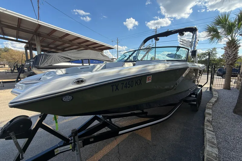 Slide: The Image of 2023 MasterCraft NXT24 boat on trailer under clear sky. - 4