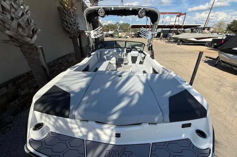 Slide: The Image of 2023 MasterCraft NXT24 boat with sleek design, docked outdoors under a sunny sky. - 8