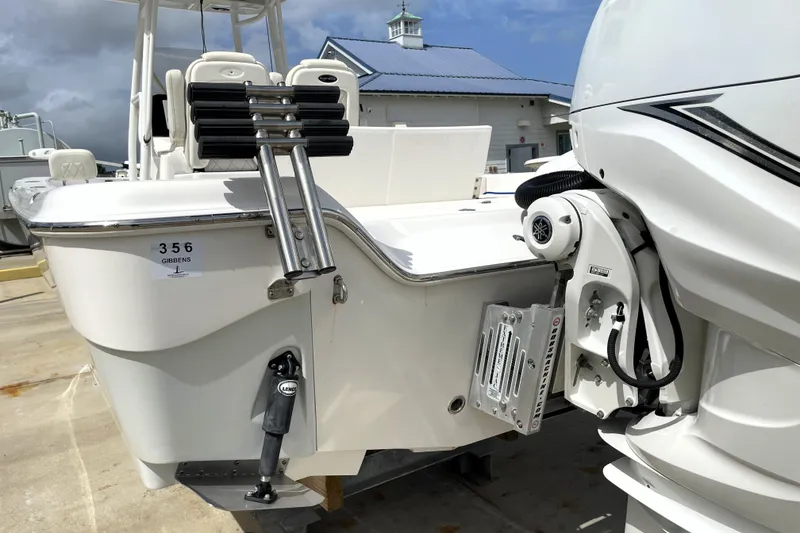 Slide: The Image of 2019 Blue Wave 2800 Pure Hybrid boat with motor and ladder, docked outdoors. - 11