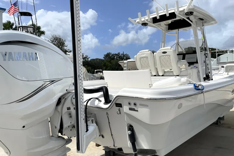 Slide: The Image of 2019 Blue Wave 2800 Pure Hybrid boat with Yamaha engine, docked under clear skies. - 12