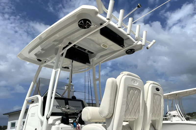 Slide: The Image of 2019 Blue Wave 2800 Pure Hybrid boat with luxury seating and rod holders under a cloudy sky. - 17