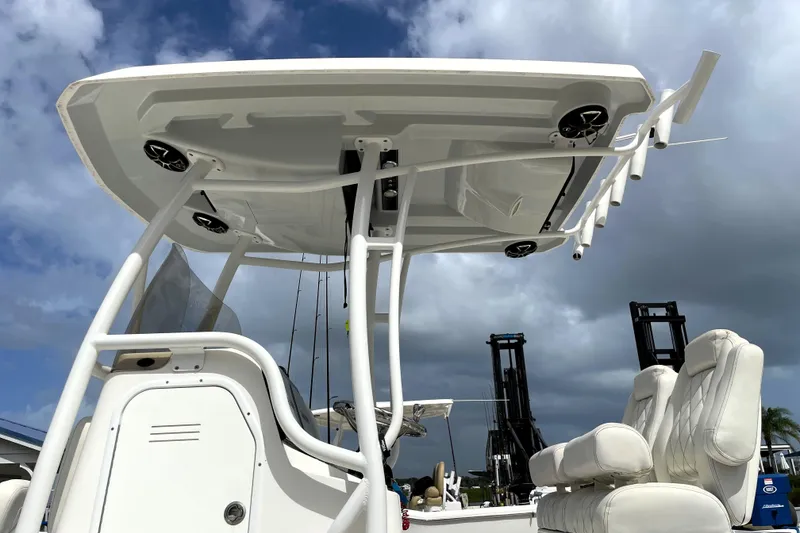 Slide: The Image of 2019 Blue Wave 2800 Pure Hybrid boat with T-top and seating, under cloudy sky. - 18