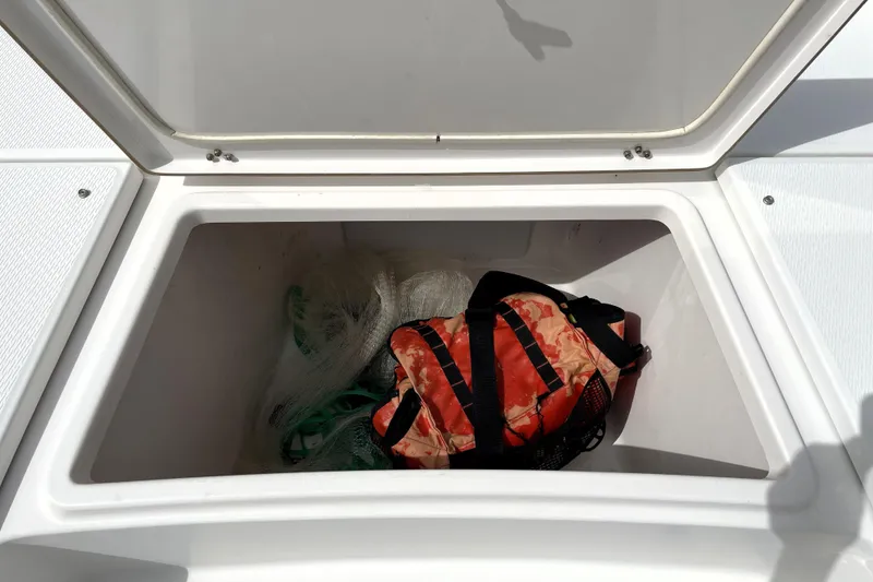 Slide: The Image of Open storage compartment on 2019 Blue Wave 2800 Pure Hybrid boat with gear inside. - 28