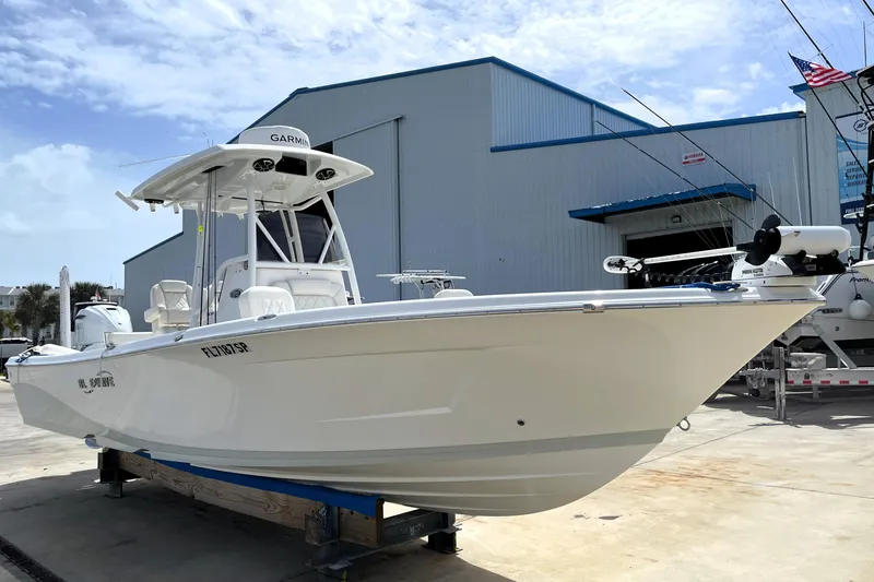Slide: The Image of 2019 Blue Wave 2800 Pure Hybrid boat displayed outdoors near a marine facility. - 5