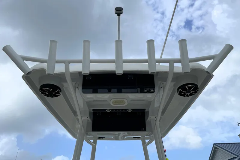 Slide: The Image of 2019 Blue Wave 2800 Pure Hybrid boat with T-top and rod holders against cloudy sky. - 58