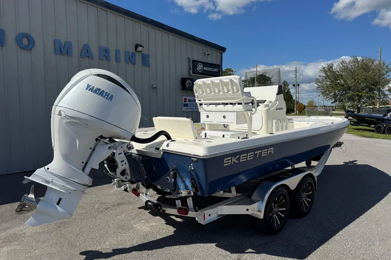 Slide: The Image of 2026 Skeeter SX221 boat with Yamaha engine on trailer, parked outside marine shop. - 10