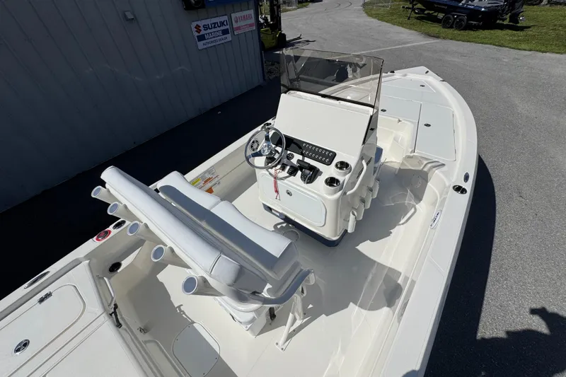 Slide: The Image of 2026 Skeeter SX221 boat interior with steering console and seating, parked outdoors. - 17