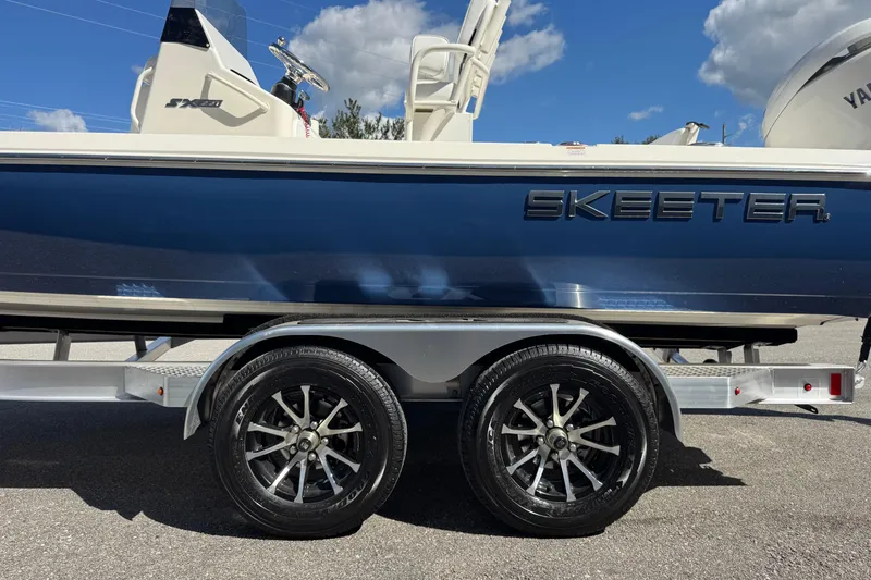 Slide: The Image of 2026 Skeeter SX221 boat on trailer, blue hull, sunny day. - 5