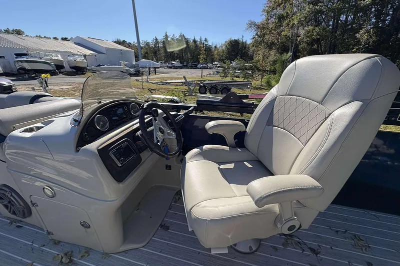 Slide: The Image of Captain's seat and helm of a 2017 Berkshire 23 boat, featuring a steering wheel and dashboard. - 11