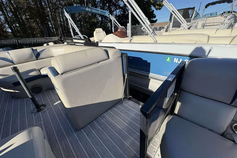 Slide: The Image of 2017 Berkshire 23 boat interior with beige seating and striped flooring. - 15