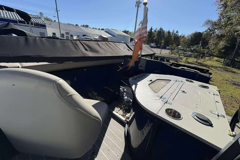 Slide: The Image of 2017 Berkshire 23 boat interior with seating and storage compartments, outdoors on a sunny day. - 18