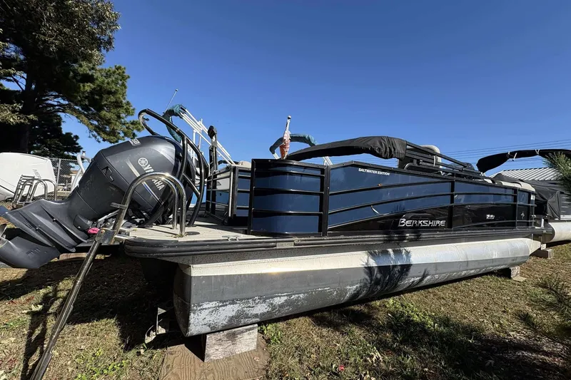 Slide: The Image of 2017 Berkshire 23 pontoon boat with Yamaha motor, parked on grass under clear blue sky. - 19