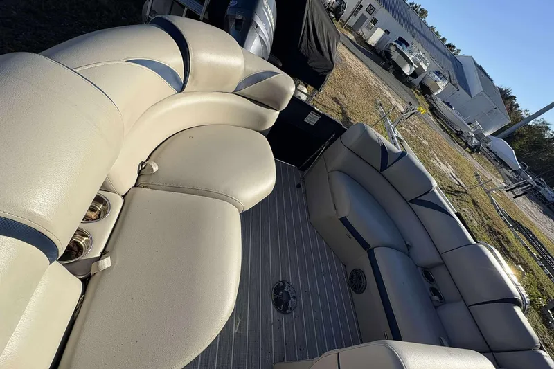 Slide: The Image of 2017 Berkshire 23 boat interior with beige seating and cup holders. - 23