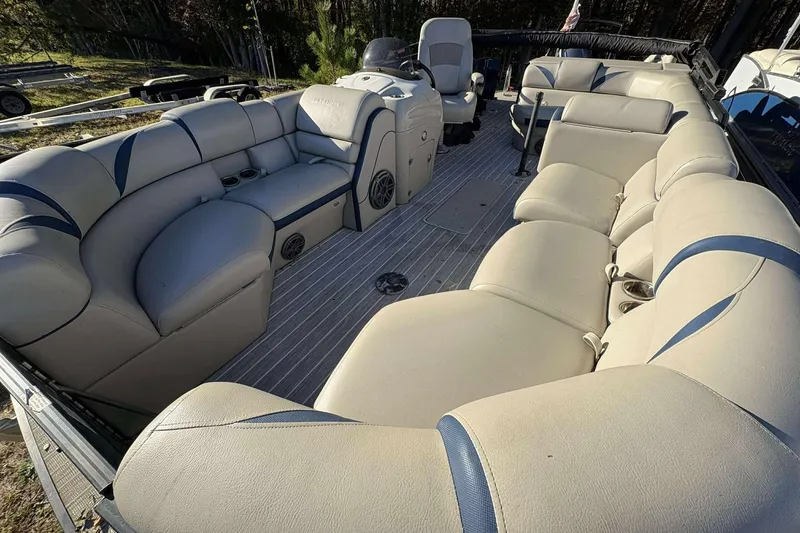 Slide: The Image of 2017 Berkshire 23 pontoon boat interior with beige seating and steering console. - 7