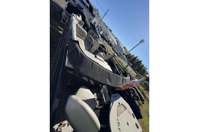 Slide: The Image of 2017 Berkshire 23 pontoon boat with covered seating, parked outdoors. - 9