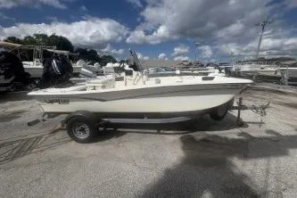 The Image of 2022 Mako Pro Skiff 15 CC boat on trailer, parked outdoors under cloudy sky. - 0