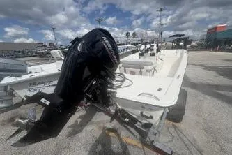 Slide: The Image of 2022 Mako Pro Skiff 15 CC boat with outboard motor in a marina setting. - 5