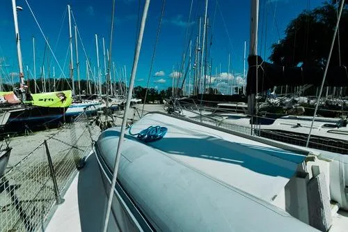 Slide: The Image of 1999 Jeanneau Sun Odyssey 42.2 sailboat with solar panels, surrounded by lush greenery. - 11