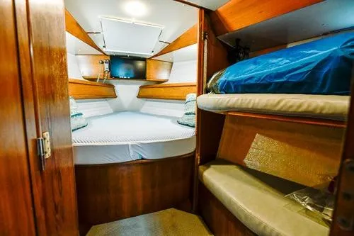 Slide: The Image of 1999 Jeanneau Sun Odyssey 42.2 cabin interior with wooden finish and cozy bedding. - 21