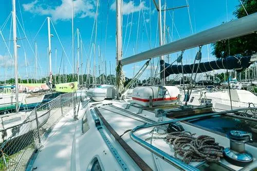 Slide: The Image of 1999 Jeanneau Sun Odyssey 42.2 sailboat on stands, named "Malik," in a boatyard. - 4