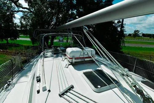 Slide: The Image of 1999 Jeanneau Sun Odyssey 42.2 sailboat on stands, outdoors, with "Malik" on the hull. - 5