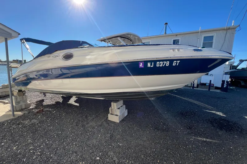 The Image of 2004 Sea Ray 240 Sundeck boat on blocks, sunny day, marina background. - 0