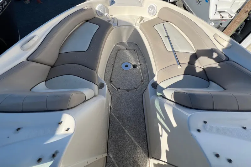 Slide: The Image of 2004 Sea Ray 240 Sundeck interior with cushioned seating and carpeted flooring. - 11