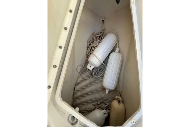 Slide: The Image of Storage compartment with boat fenders and ropes on a 2004 Sea Ray 240 Sundeck. - 13