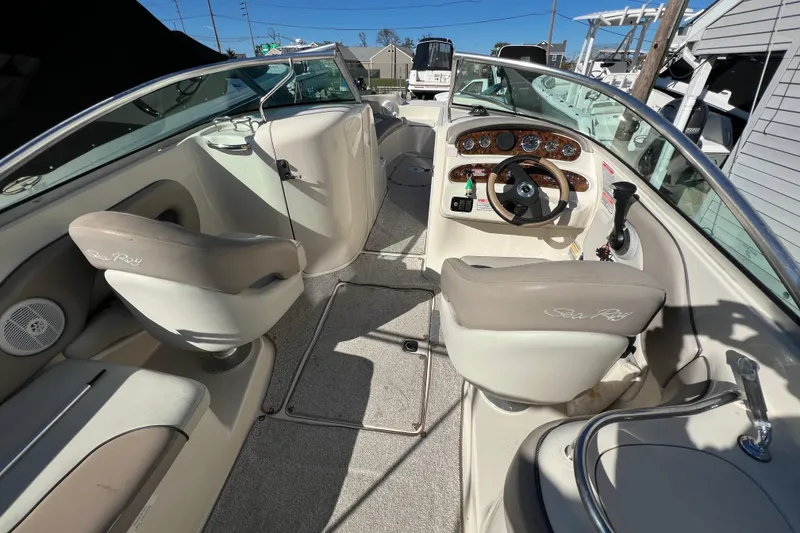 Slide: The Image of 2004 Sea Ray 240 Sundeck interior with steering wheel and seating, showcasing luxury design. - 5