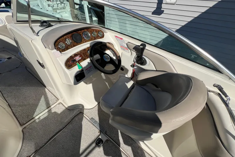 Slide: The Image of 2004 Sea Ray 240 Sundeck helm with steering wheel and control panel. - 6