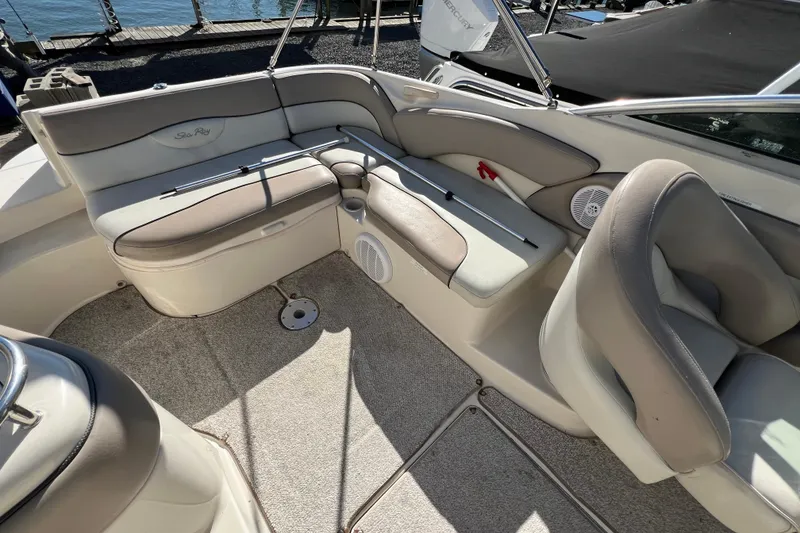 Slide: The Image of 2004 Sea Ray 240 Sundeck interior with beige seating and carpeted floor. - 8