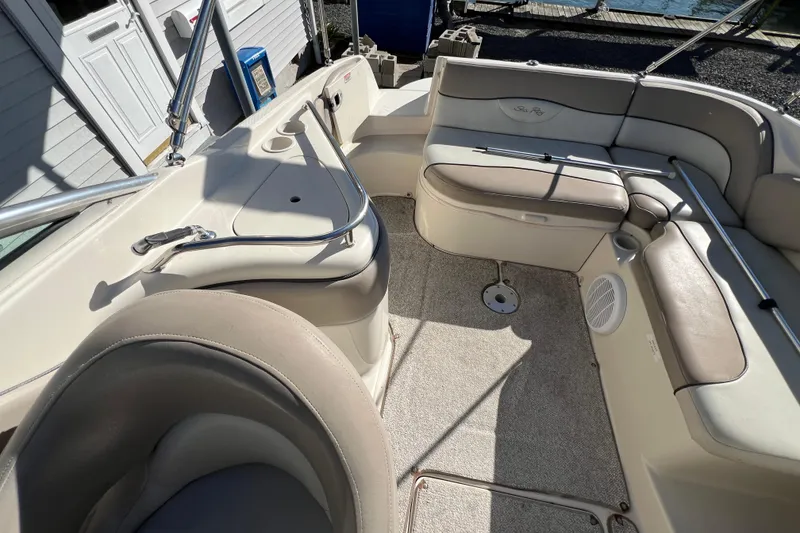 Slide: The Image of 2004 Sea Ray 240 Sundeck interior with beige seating and stainless steel railings. - 9