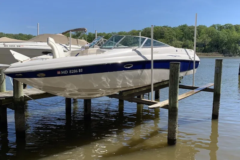 The Image of 2004 Rinker 282 Captiva Bowrider on a boat lift by the water. - 0