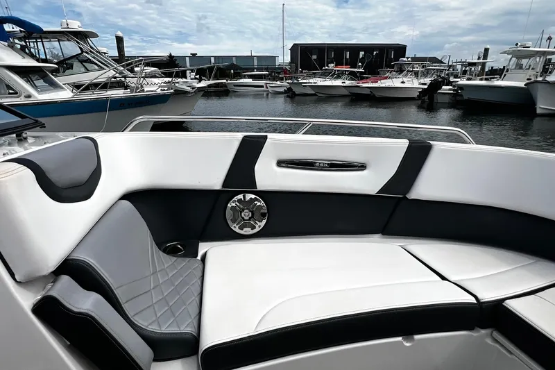 Slide: The Image of 2020 Chaparral 297 SSX boat interior with luxurious seating at a marina. - 33