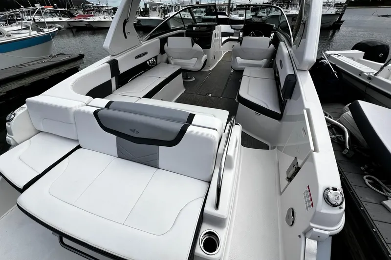 Slide: The Image of 2020 Chaparral 297 SSX boat interior with spacious seating at a marina. - 34