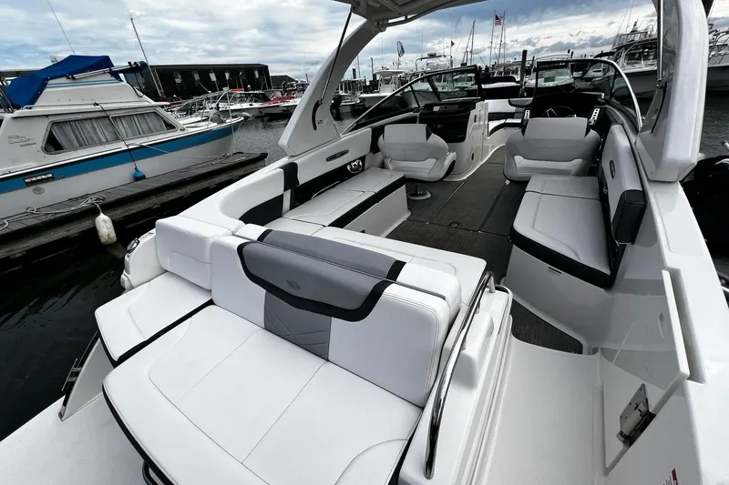 Slide: The Image of 2020 Chaparral 297 SSX boat interior with luxurious seating at a marina. - 4