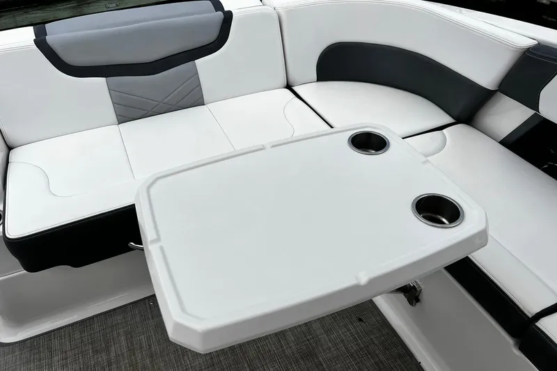 Slide: The Image of 2020 Chaparral 297 SSX boat interior with white seating and table with cup holders. - 9