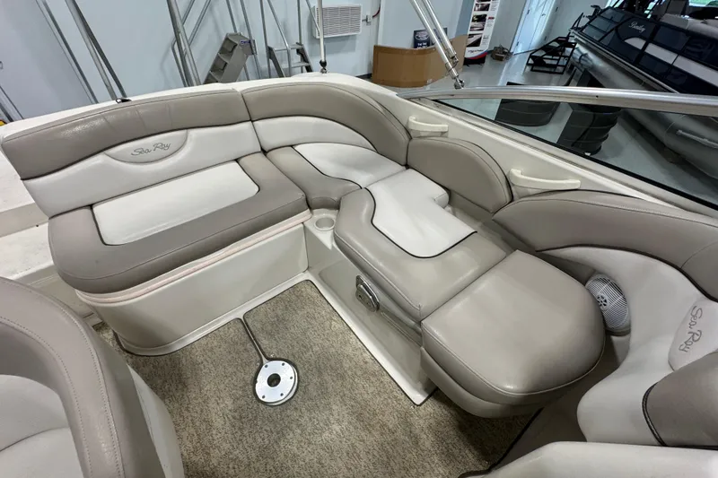 Slide: The Image of 2004 Sea Ray 200 Sundeck interior with beige seating and carpeted flooring. - 10