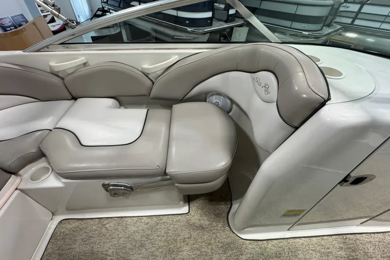 Slide: The Image of 2004 Sea Ray 200 Sundeck interior with beige seating and cup holder. - 11