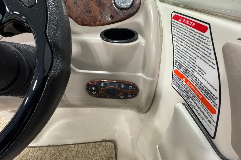 Slide: The Image of 2004 Sea Ray 200 Sundeck dashboard with steering wheel and warning labels. - 16