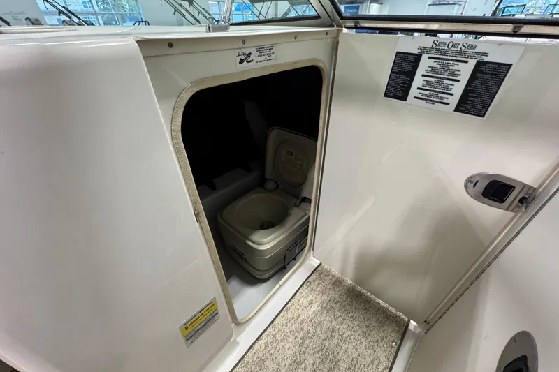 Slide: The Image of 2004 Sea Ray 200 Sundeck interior with portable toilet compartment. - 22