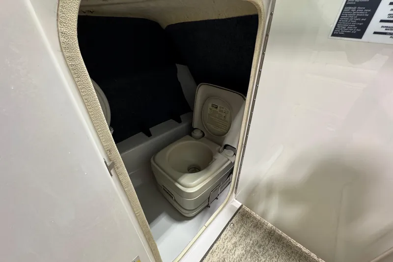 Slide: The Image of Portable toilet inside 2004 Sea Ray 200 Sundeck boat compartment. - 23