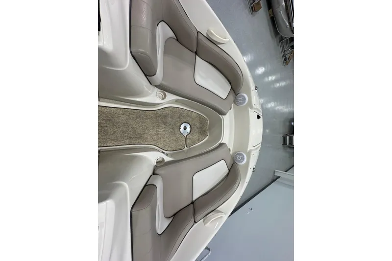 Slide: The Image of 2004 Sea Ray 200 Sundeck interior with beige seating and carpeted floor. - 24