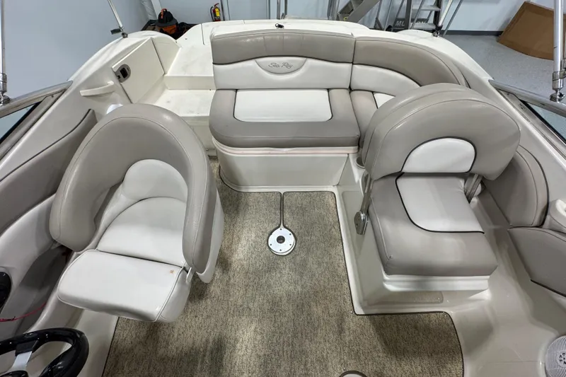 Slide: The Image of 2004 Sea Ray 200 Sundeck interior with beige seating and carpeted floor. - 8