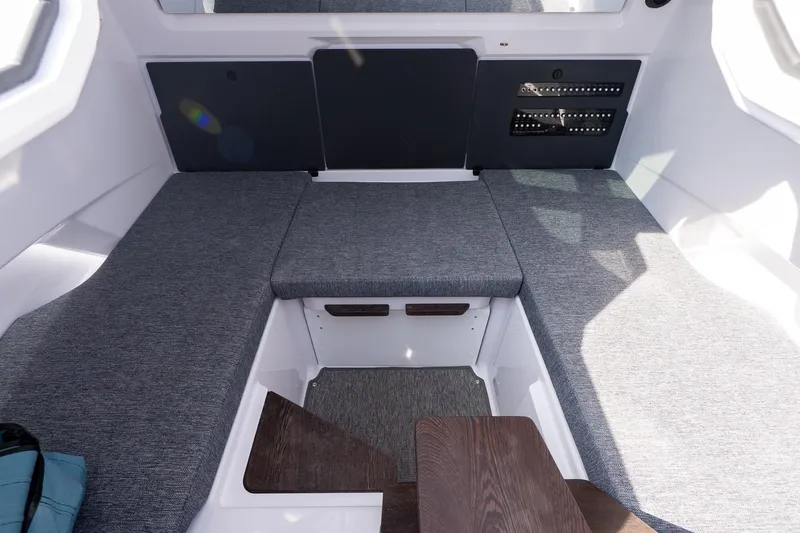 Slide: The Image of Interior of 2026 Axopar 29 Cross Cabin with gray seating and wooden accents. - 12