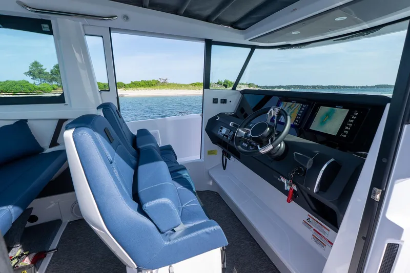Slide: The Image of Interior of 2026 Axopar 29 Cross Cabin boat with blue seating and navigation screens. - 28