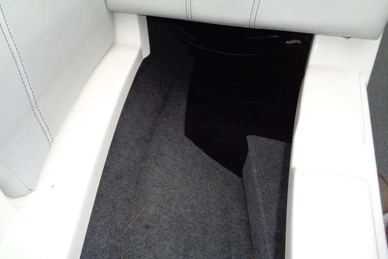 Slide: The Image of Interior view of a 2020 MasterCraft XT23 boat, featuring carpeted flooring and white seating. - 29
